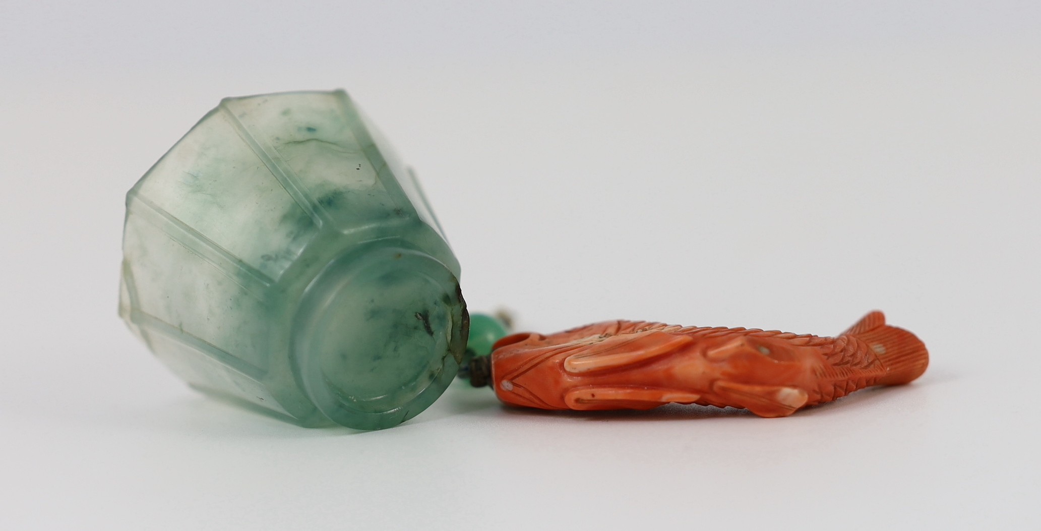 A Chinese jadeite small cup and a coral 'fish' pendant, 19th/20th century